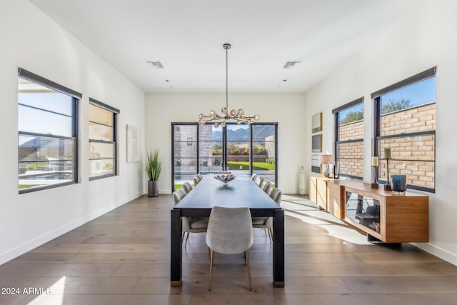 dining area featuring an inviting chandelier and dark wood-type flooring