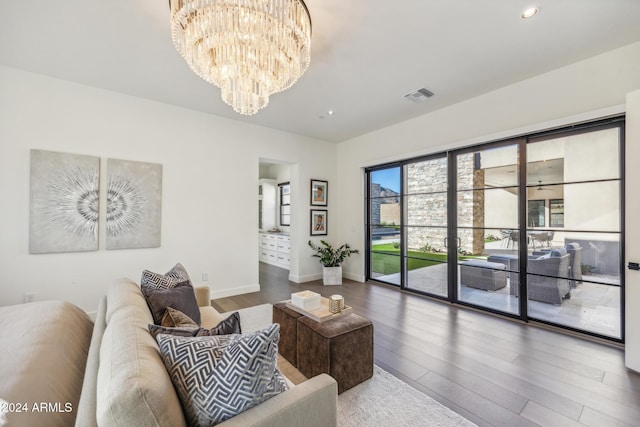 living room with wood-type flooring and an inviting chandelier