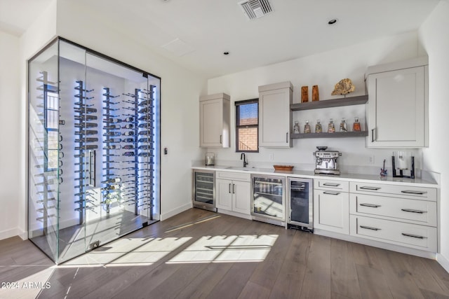 bar with dark hardwood / wood-style floors, sink, and wine cooler