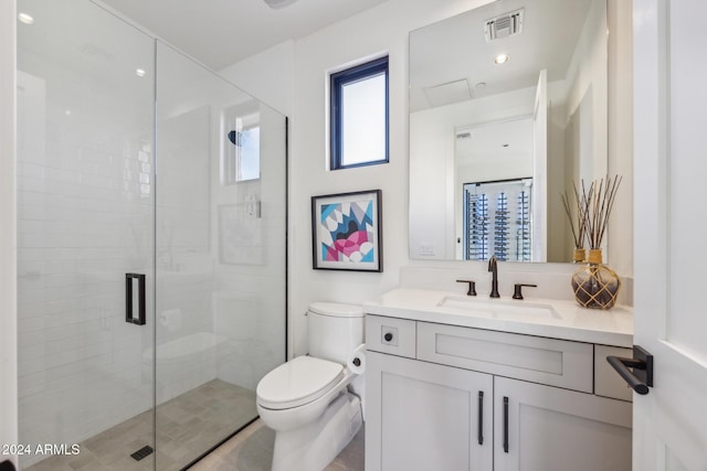 bathroom featuring a shower with door, vanity, and toilet