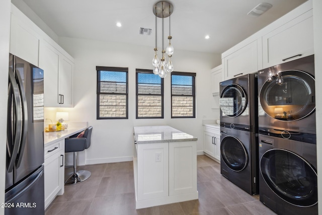 washroom with a notable chandelier, separate washer and dryer, and stacked washer / dryer