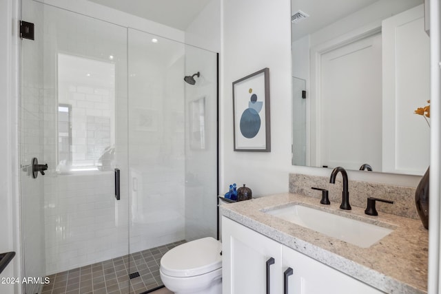 bathroom featuring a shower with door, vanity, and toilet