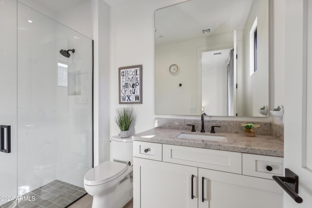 bathroom with vanity, toilet, and a shower with shower door