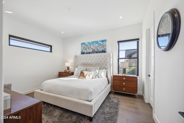 bedroom with multiple windows and hardwood / wood-style floors