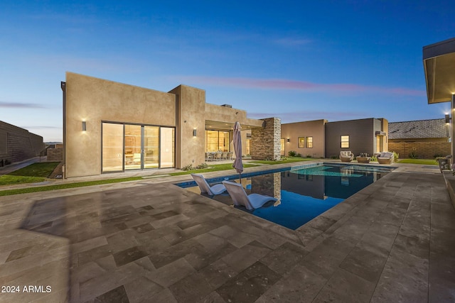 pool at dusk with a patio