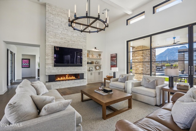 living room with hardwood / wood-style flooring, a healthy amount of sunlight, a fireplace, and a high ceiling