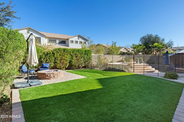 view of yard featuring a fenced backyard, a fire pit, and a patio