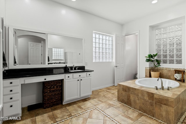 bathroom with recessed lighting, toilet, vanity, baseboards, and a bath