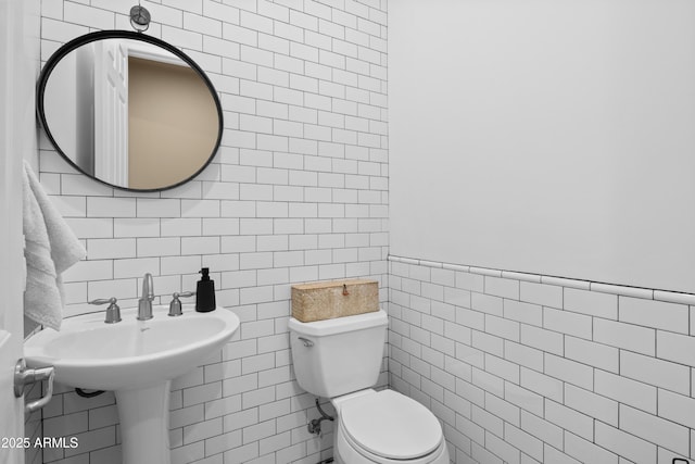 bathroom with tile walls and toilet