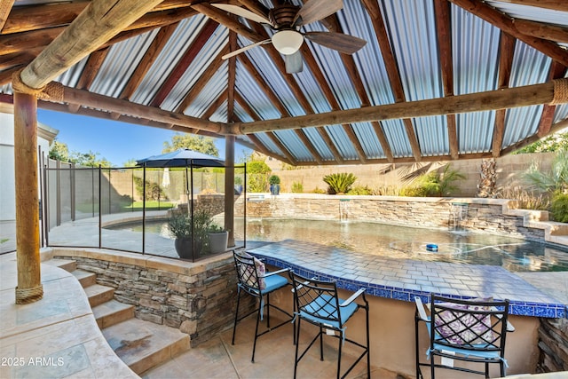 view of patio with a ceiling fan, fence, outdoor dry bar, and a gazebo