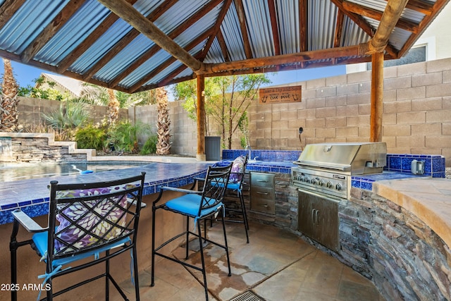 view of patio / terrace with outdoor dry bar, exterior kitchen, area for grilling, and a fenced backyard