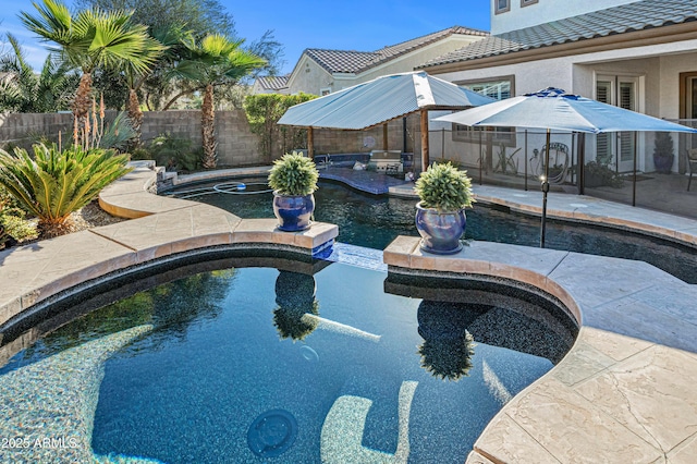 view of swimming pool with a patio area, a fenced backyard, and a pool with connected hot tub