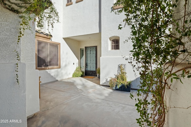 property entrance featuring a patio area and stucco siding