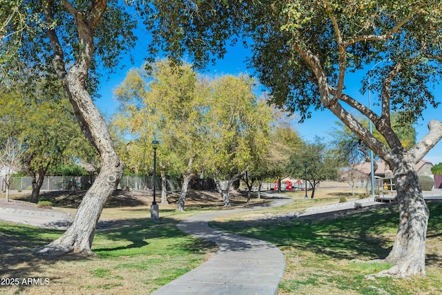 view of property's community featuring fence and a yard