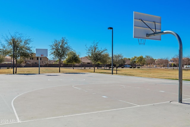 view of basketball court with community basketball court and a lawn