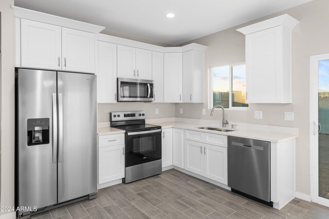 kitchen with white cabinets, decorative light fixtures, stainless steel appliances, and dark hardwood / wood-style floors