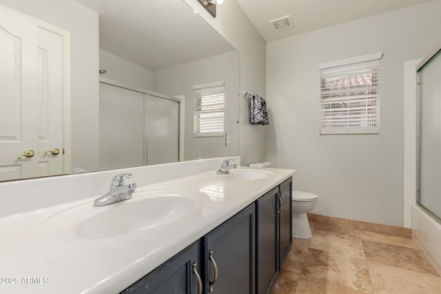 full bathroom featuring enclosed tub / shower combo, vanity, and toilet