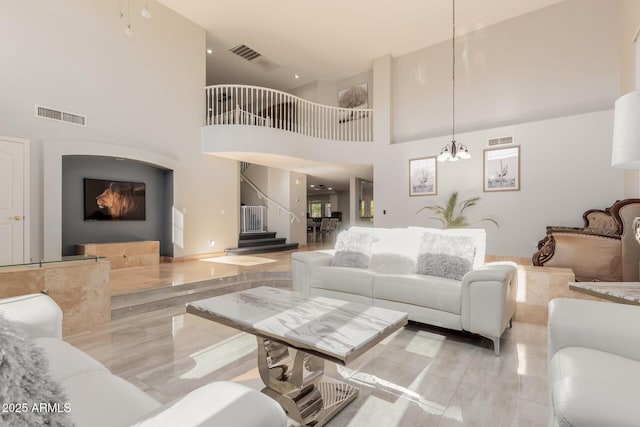 living room with a towering ceiling and a notable chandelier