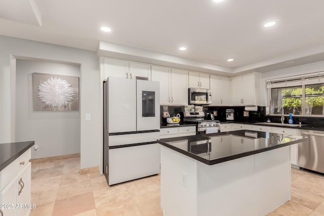 kitchen with sink, white cabinetry, stainless steel appliances, a center island, and tasteful backsplash