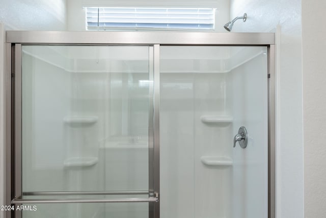 bathroom featuring a shower with shower door