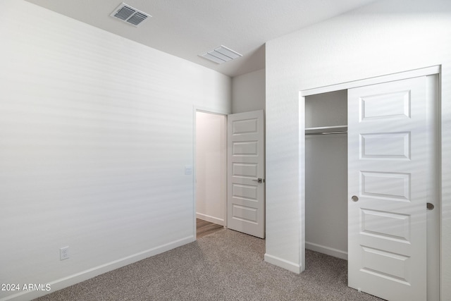 unfurnished bedroom featuring carpet floors and a closet