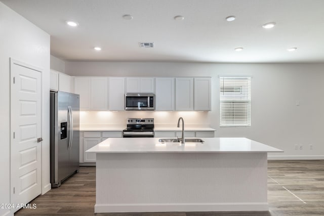 kitchen featuring white cabinetry, sink, a center island with sink, appliances with stainless steel finishes, and light wood-type flooring