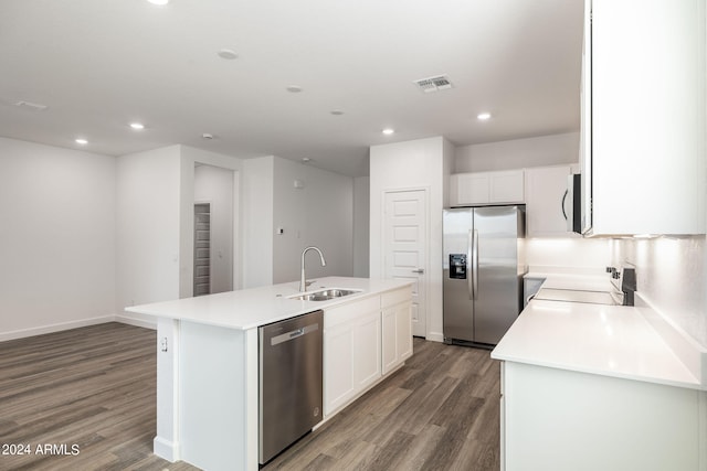 kitchen with white cabinets, appliances with stainless steel finishes, a kitchen island with sink, and sink