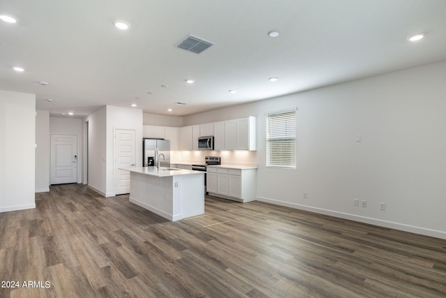 kitchen featuring sink, dark wood-type flooring, stainless steel appliances, a kitchen island with sink, and white cabinets