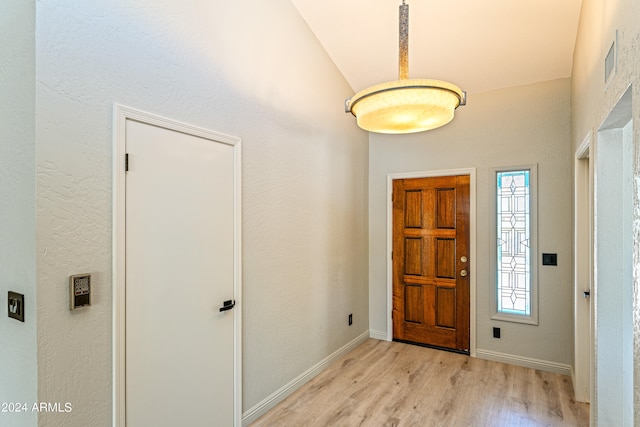 foyer entrance featuring light wood-type flooring and lofted ceiling