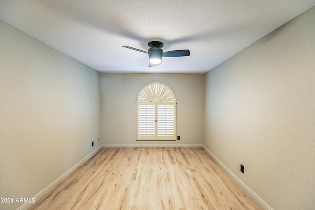 spare room featuring a textured ceiling, light hardwood / wood-style floors, and ceiling fan