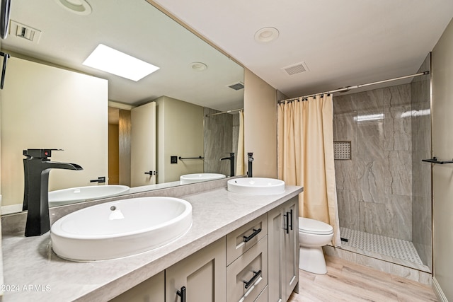 bathroom with vanity, toilet, hardwood / wood-style flooring, and curtained shower