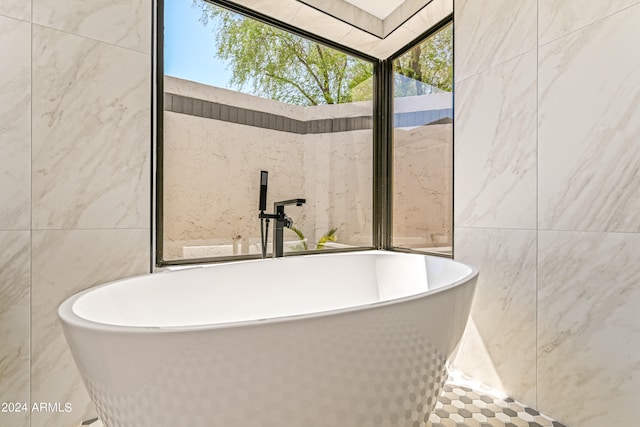 bathroom featuring a bathtub and tile walls