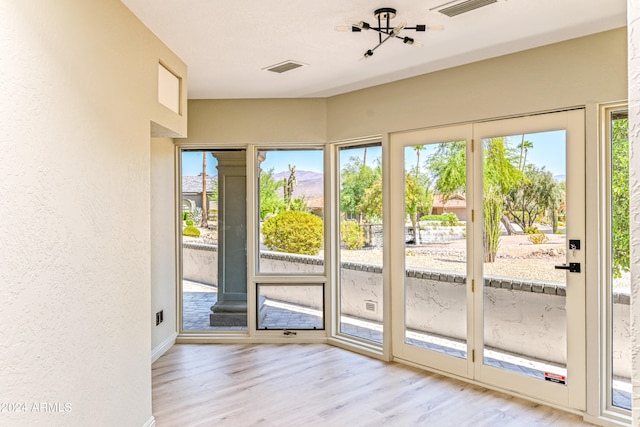 entryway featuring light hardwood / wood-style flooring and a chandelier