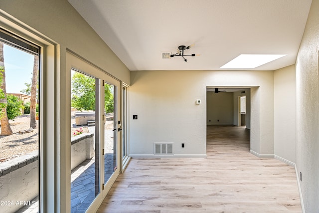 interior space with light wood-type flooring and a skylight