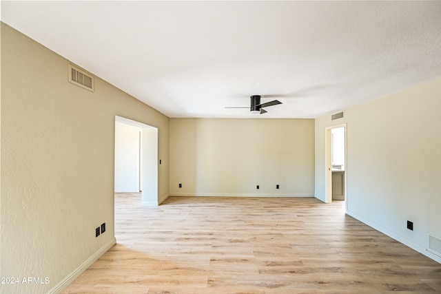 empty room with ceiling fan and light hardwood / wood-style flooring