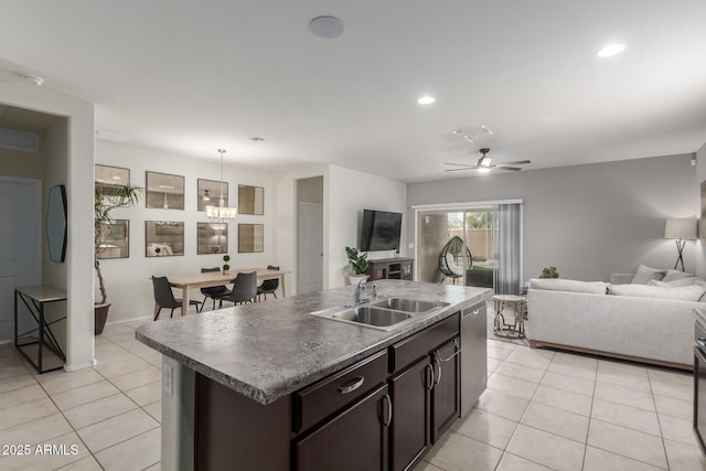 kitchen with a sink, stainless steel dishwasher, open floor plan, and light tile patterned floors