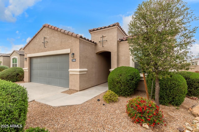 mediterranean / spanish-style home featuring stucco siding, a tile roof, and a garage