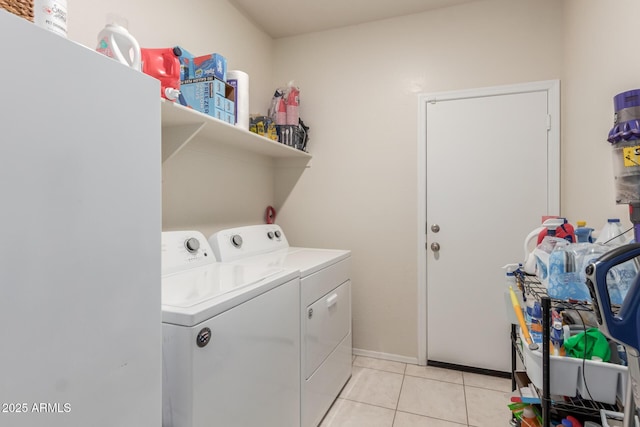 clothes washing area with laundry area, light tile patterned floors, and washer and clothes dryer