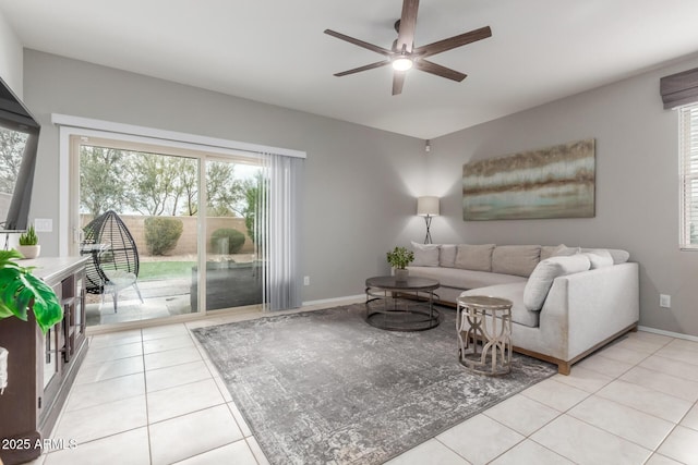 living room with light tile patterned floors, a ceiling fan, and baseboards