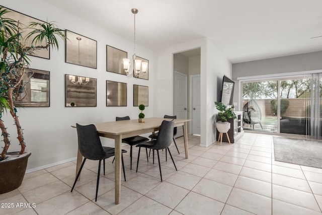 dining space with light tile patterned floors, baseboards, and a chandelier