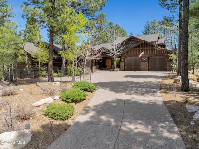 view of front of house featuring a garage, driveway, and stone siding