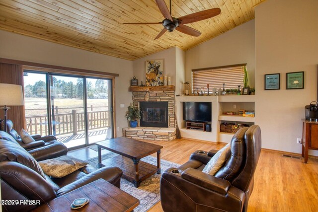 living room with lofted ceiling, light wood finished floors, a stone fireplace, wood ceiling, and ceiling fan