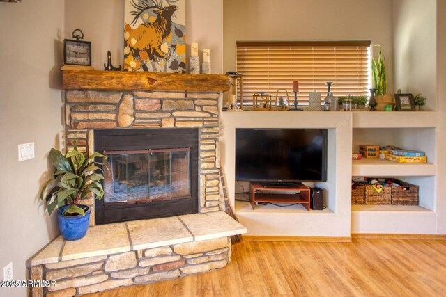 living area with a fireplace and wood finished floors