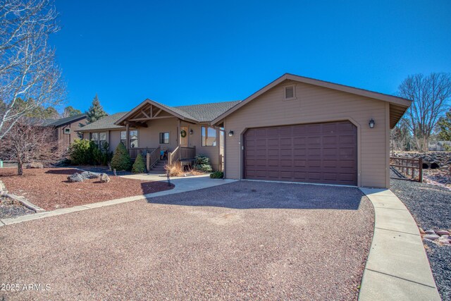 ranch-style house with an attached garage and aphalt driveway