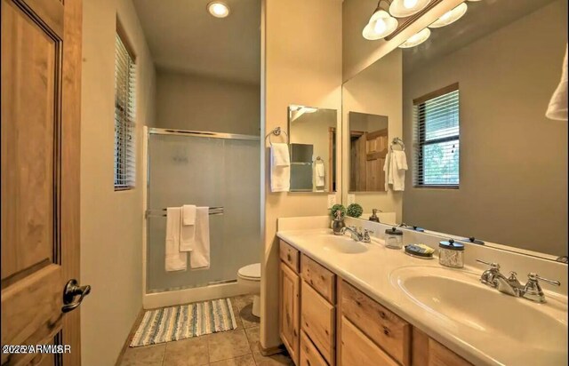 bathroom with tile patterned floors, a stall shower, toilet, and a sink