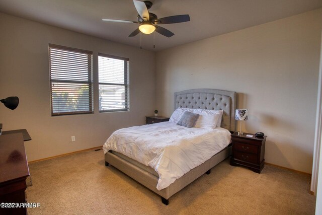 bedroom featuring light carpet, baseboards, and ceiling fan