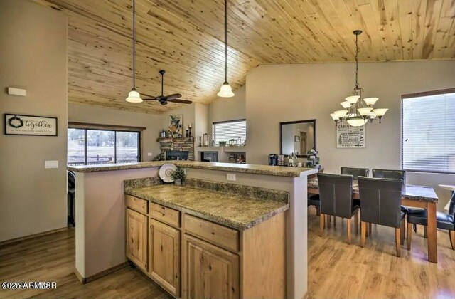 kitchen featuring vaulted ceiling, wooden ceiling, and ceiling fan with notable chandelier