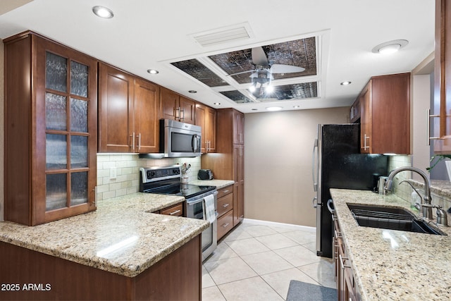 kitchen featuring visible vents, appliances with stainless steel finishes, glass insert cabinets, a sink, and ceiling fan