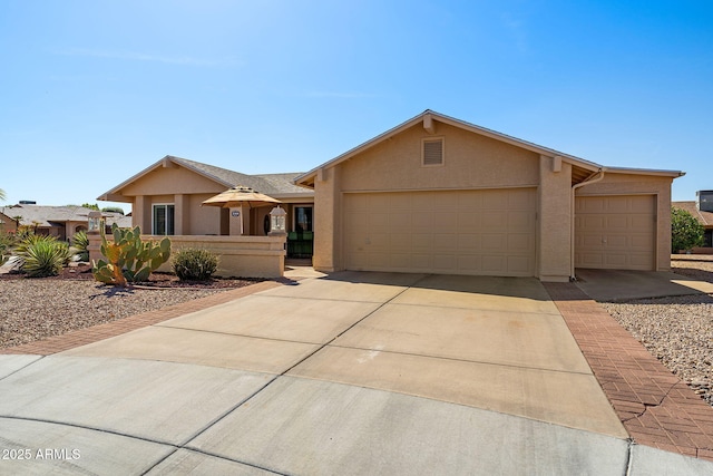 ranch-style house with a garage, driveway, and stucco siding