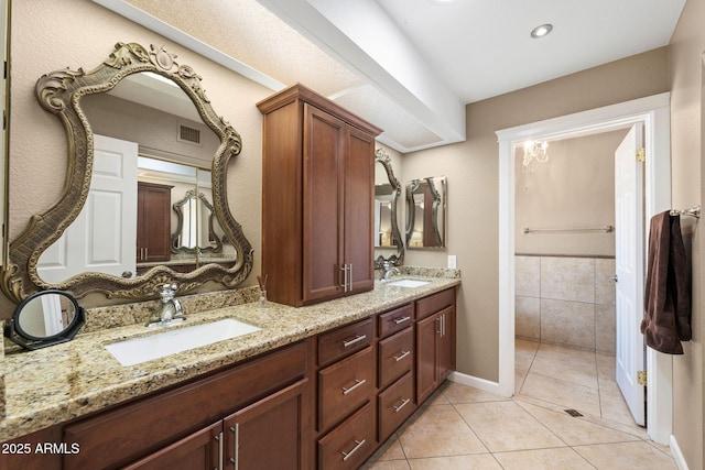 bathroom featuring tile patterned flooring, visible vents, a sink, and double vanity